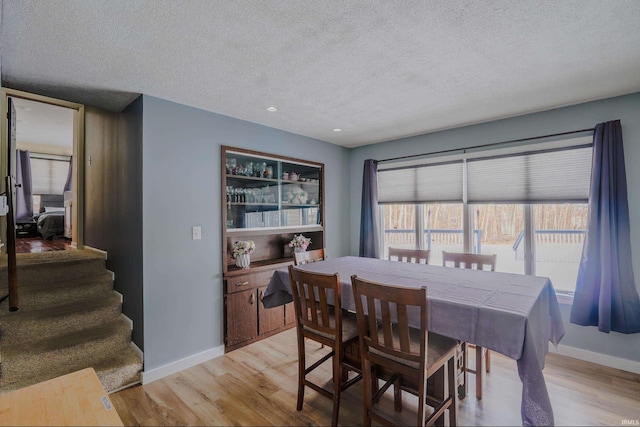 dining space featuring a textured ceiling and light hardwood / wood-style floors