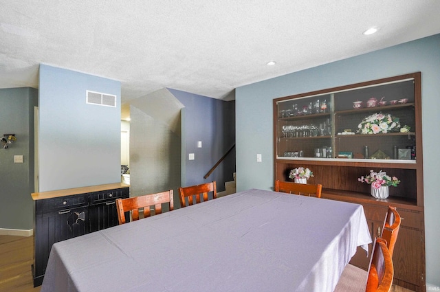 dining space featuring hardwood / wood-style flooring and a textured ceiling