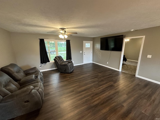 living room featuring a textured ceiling, ceiling fan, and dark wood-type flooring