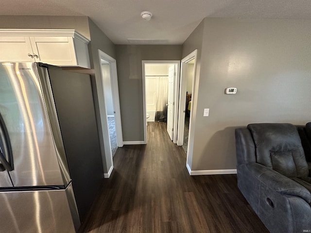 interior space featuring white cabinetry, stainless steel refrigerator, and dark hardwood / wood-style floors