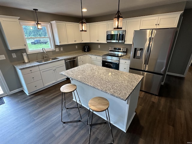 kitchen featuring hanging light fixtures, sink, a kitchen island, and stainless steel appliances