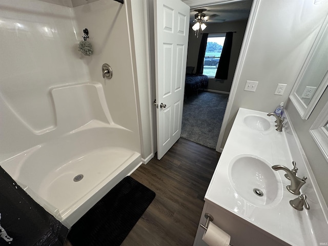 bathroom featuring a shower, vanity, and hardwood / wood-style flooring