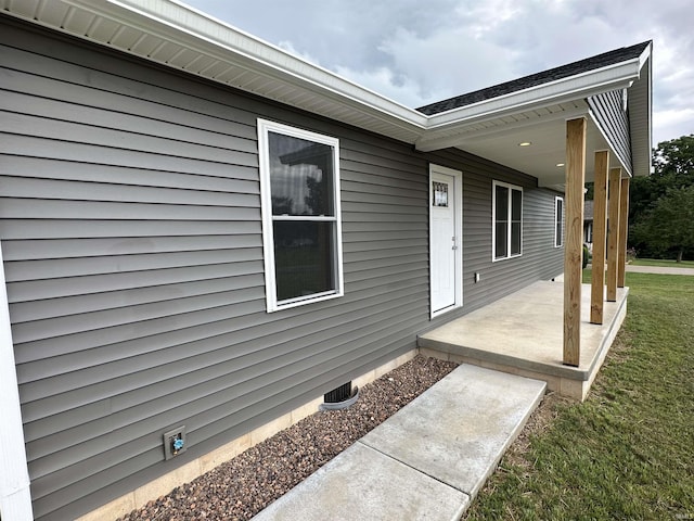 property entrance featuring a lawn