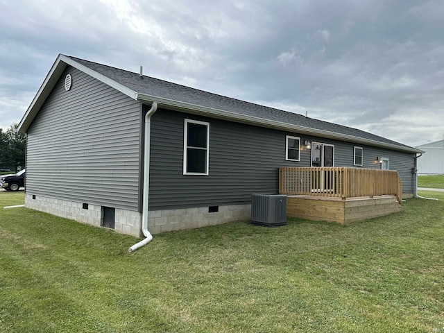 back of house featuring a lawn, a deck, and central AC