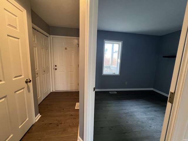 hallway with dark hardwood / wood-style flooring