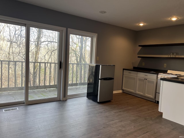 kitchen featuring white range oven, white cabinetry, and dark wood-type flooring