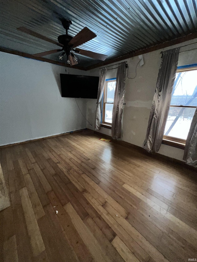 unfurnished room featuring ceiling fan, a healthy amount of sunlight, and hardwood / wood-style flooring