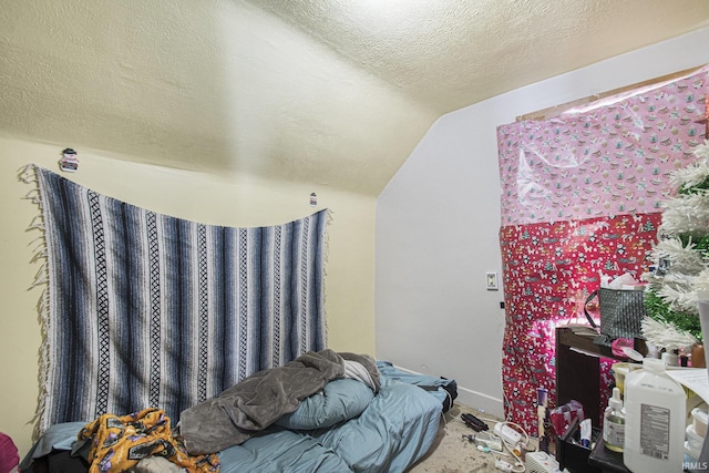 bedroom with lofted ceiling and a textured ceiling