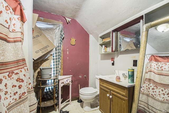 bathroom featuring vanity, a textured ceiling, vaulted ceiling, and toilet