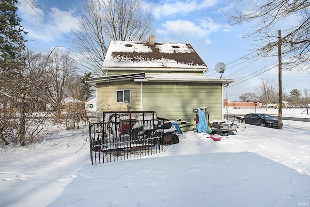 view of snow covered back of property