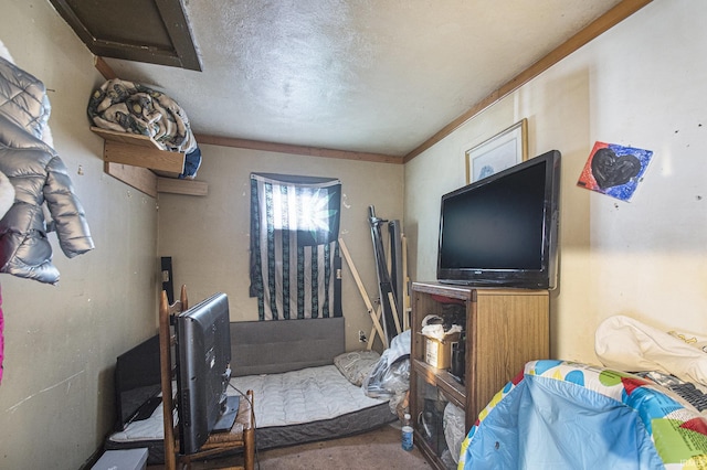 bedroom with a textured ceiling, carpet floors, and ornamental molding