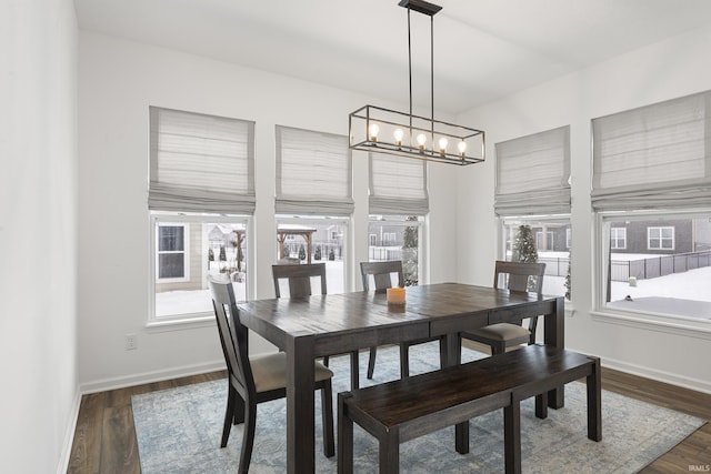 dining space featuring baseboards and dark wood-style flooring