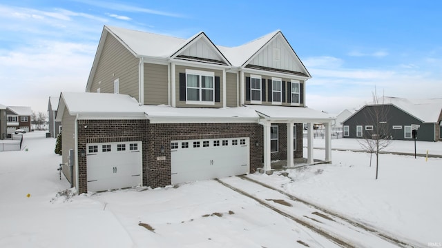 view of front of property with board and batten siding, covered porch, brick siding, and a garage