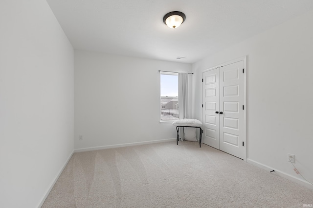 carpeted empty room featuring baseboards