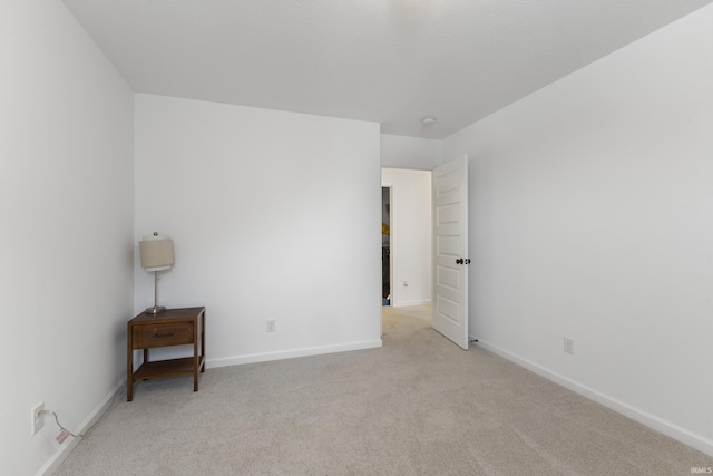 unfurnished bedroom with baseboards and light colored carpet