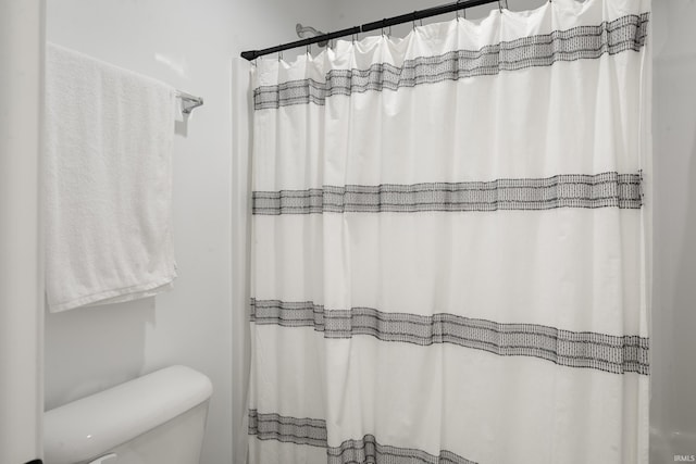 bathroom with toilet and curtained shower