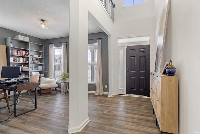 entryway featuring dark wood-style floors, baseboards, and a textured ceiling