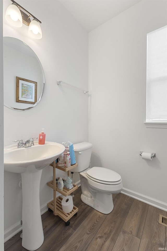 bathroom featuring hardwood / wood-style floors and toilet