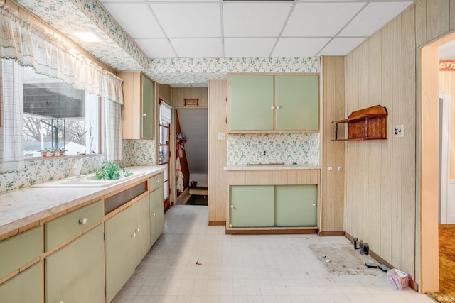 kitchen with a paneled ceiling, sink, and green cabinetry