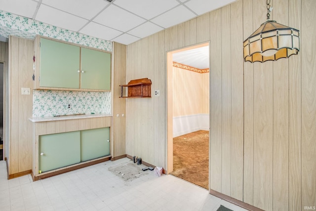 kitchen with a paneled ceiling, hanging light fixtures, and green cabinetry