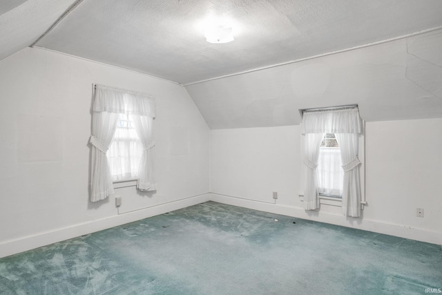 bonus room with carpet flooring, a textured ceiling, and vaulted ceiling