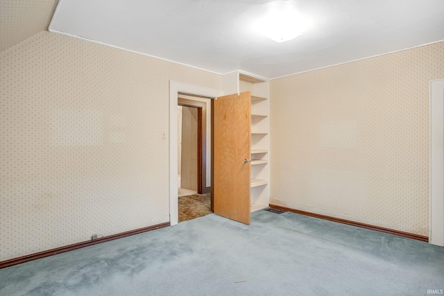 unfurnished bedroom with carpet and vaulted ceiling