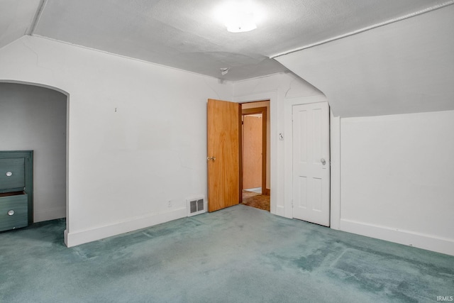 bonus room featuring carpet flooring, lofted ceiling, and a textured ceiling