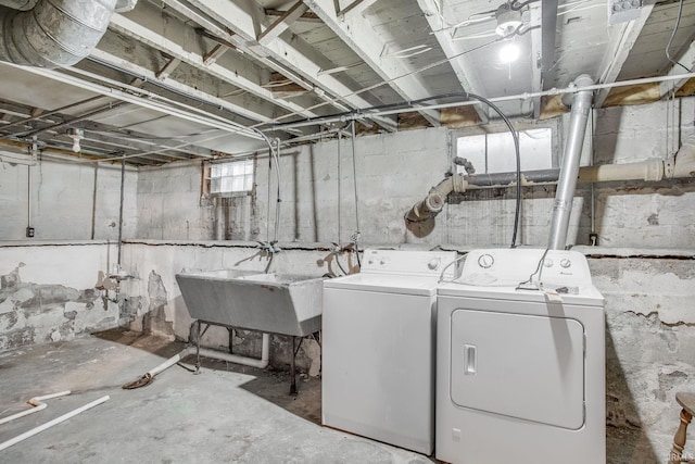 clothes washing area with washer and clothes dryer and sink