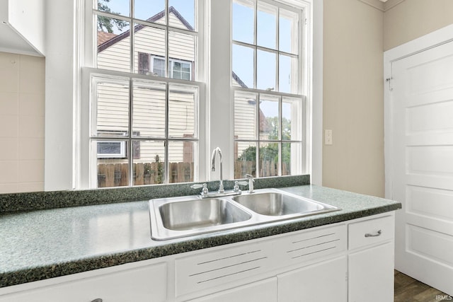 kitchen featuring plenty of natural light, dark hardwood / wood-style flooring, white cabinetry, and sink