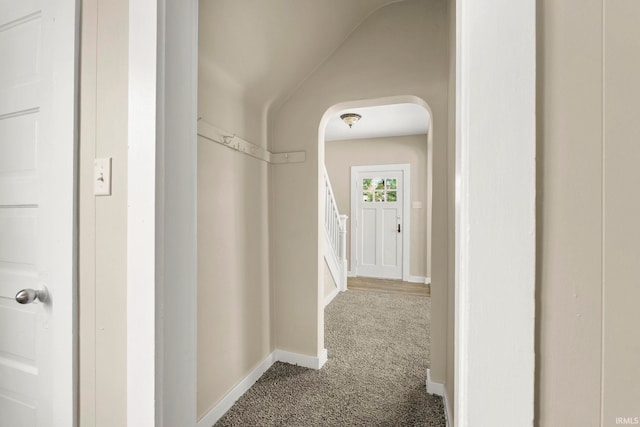 corridor featuring carpet and vaulted ceiling