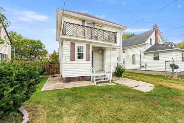 rear view of property with a lawn and a balcony