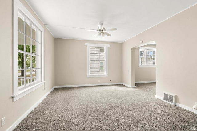 carpeted spare room with plenty of natural light and ceiling fan