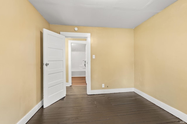 unfurnished room with dark wood-type flooring