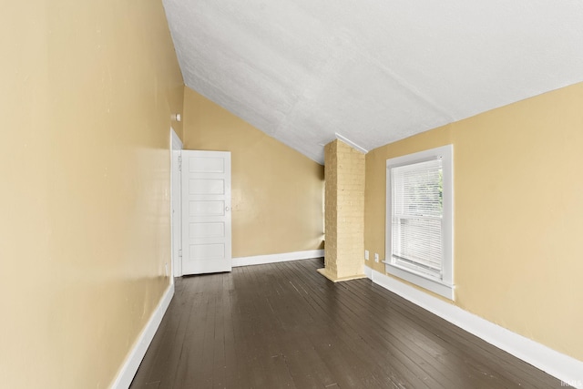 interior space with dark hardwood / wood-style floors and vaulted ceiling