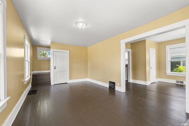 spare room with dark hardwood / wood-style floors and plenty of natural light