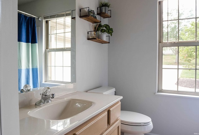 bathroom featuring vanity, toilet, and a wealth of natural light