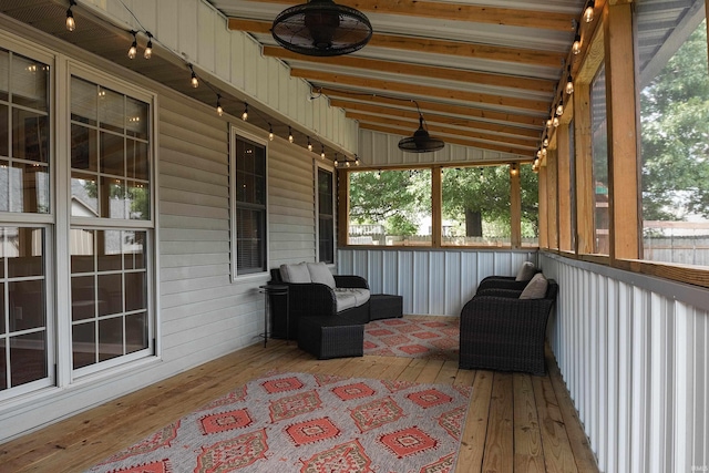 sunroom / solarium featuring lofted ceiling with beams