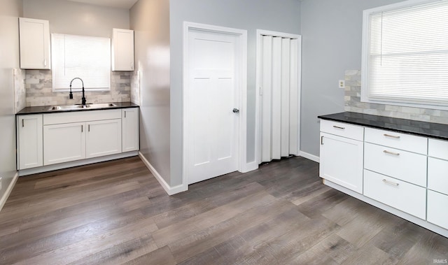 kitchen with white cabinets, decorative backsplash, sink, and hardwood / wood-style floors