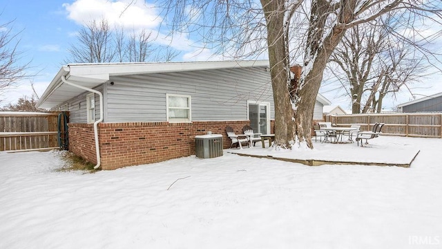 snow covered property featuring central AC