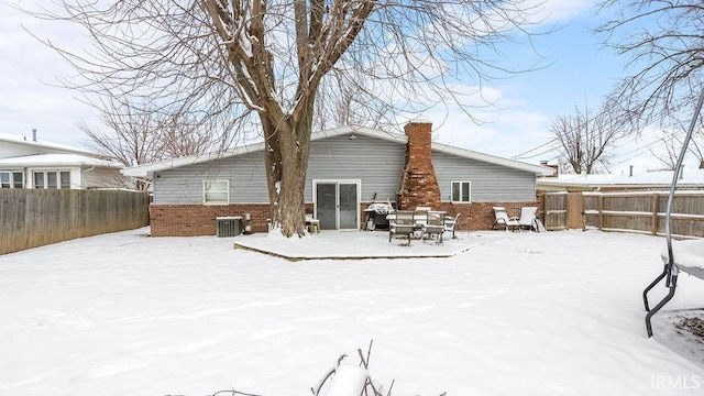 snow covered property featuring cooling unit