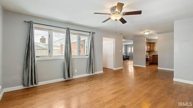 spare room with light hardwood / wood-style floors, a wealth of natural light, and ceiling fan