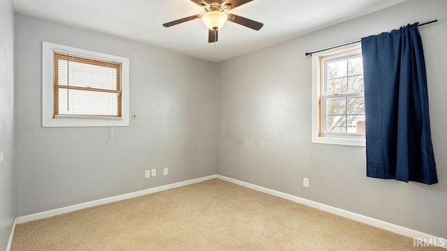 carpeted spare room featuring ceiling fan