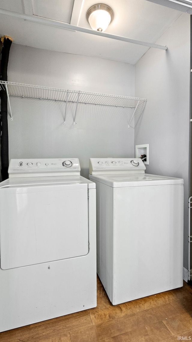 clothes washing area featuring hardwood / wood-style floors and washing machine and clothes dryer