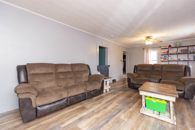 living room featuring hardwood / wood-style floors, ceiling fan, and ornamental molding