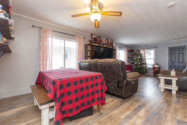 dining area with wood-type flooring, a wealth of natural light, crown molding, and ceiling fan