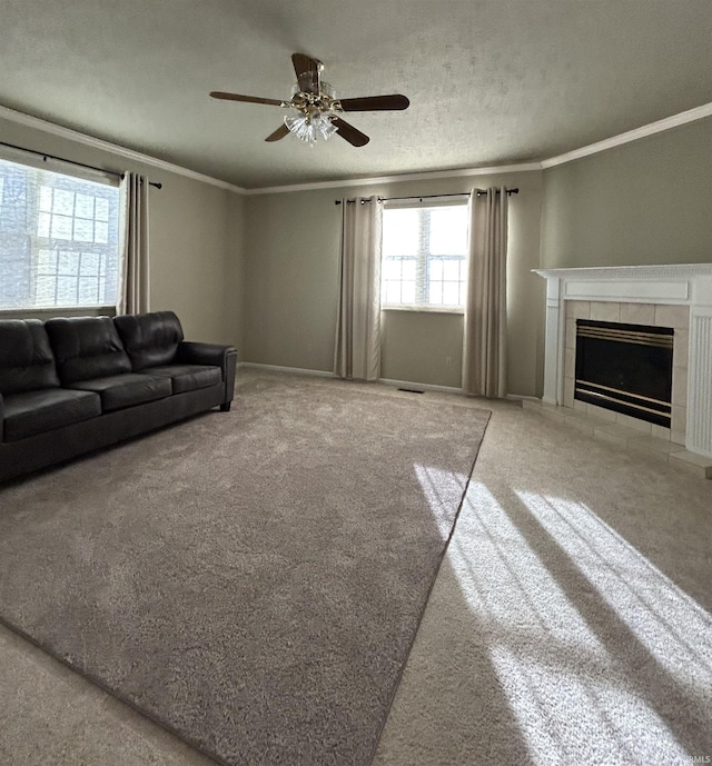 unfurnished living room with ceiling fan, crown molding, carpet floors, and a fireplace