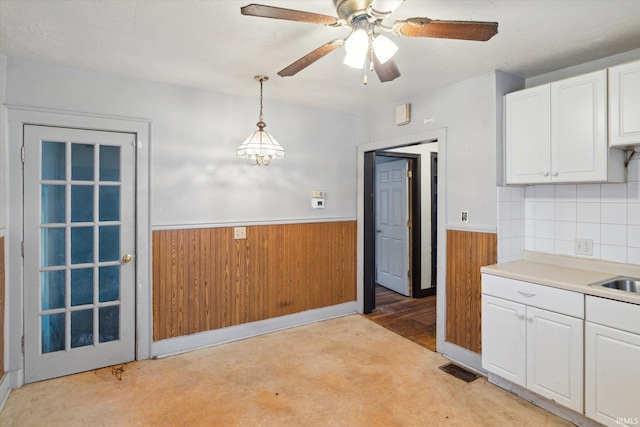 kitchen featuring light carpet, ceiling fan with notable chandelier, sink, decorative light fixtures, and white cabinets