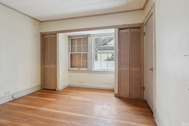 unfurnished bedroom with light wood-type flooring and crown molding