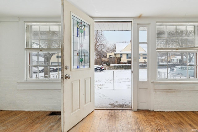 doorway featuring wood-type flooring and crown molding