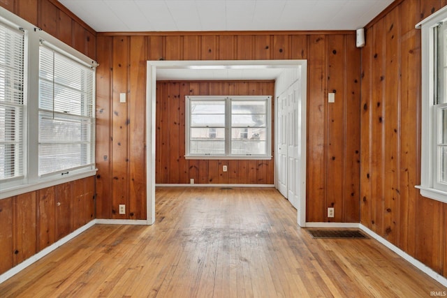 interior space featuring light wood-type flooring and wooden walls